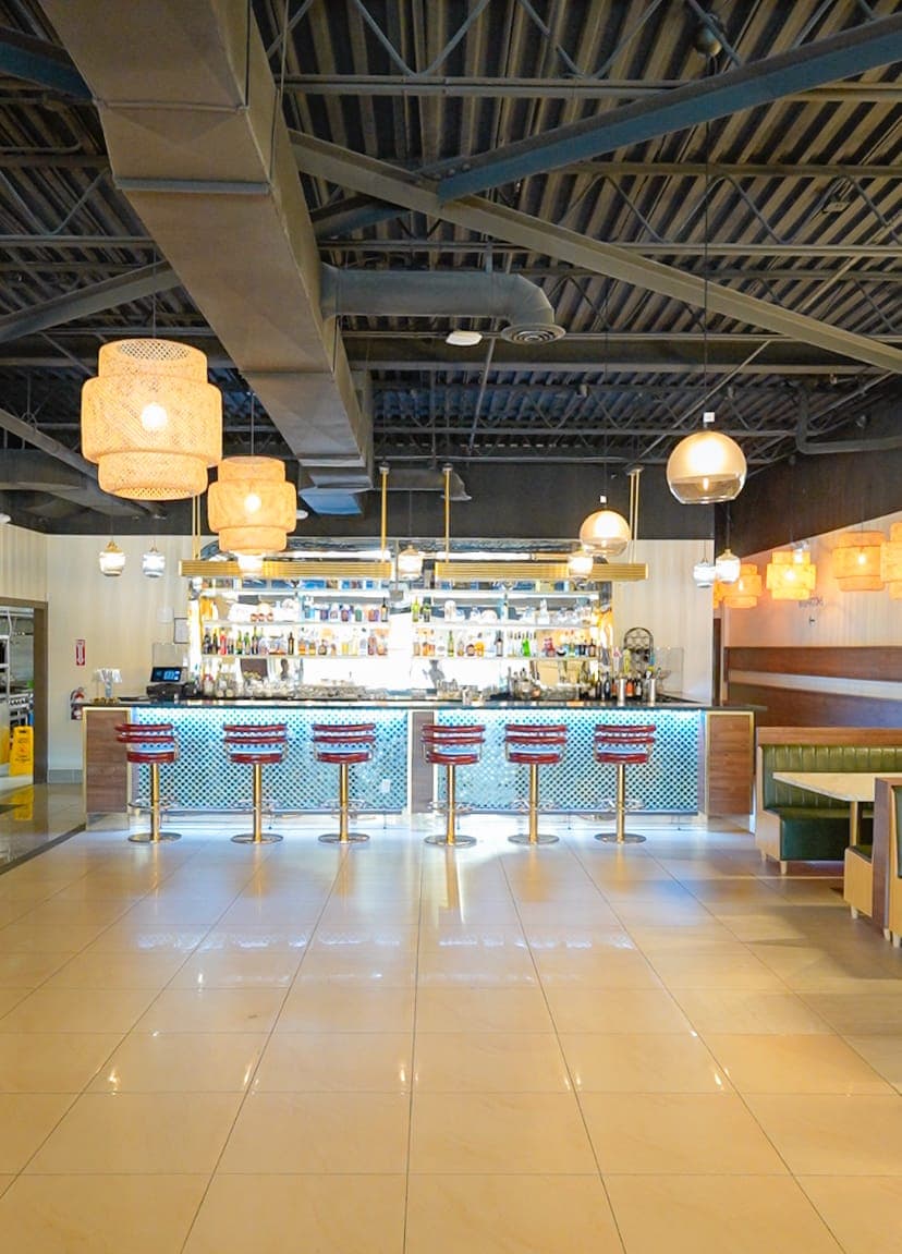 Wide view of the restaurant bar and stool seating