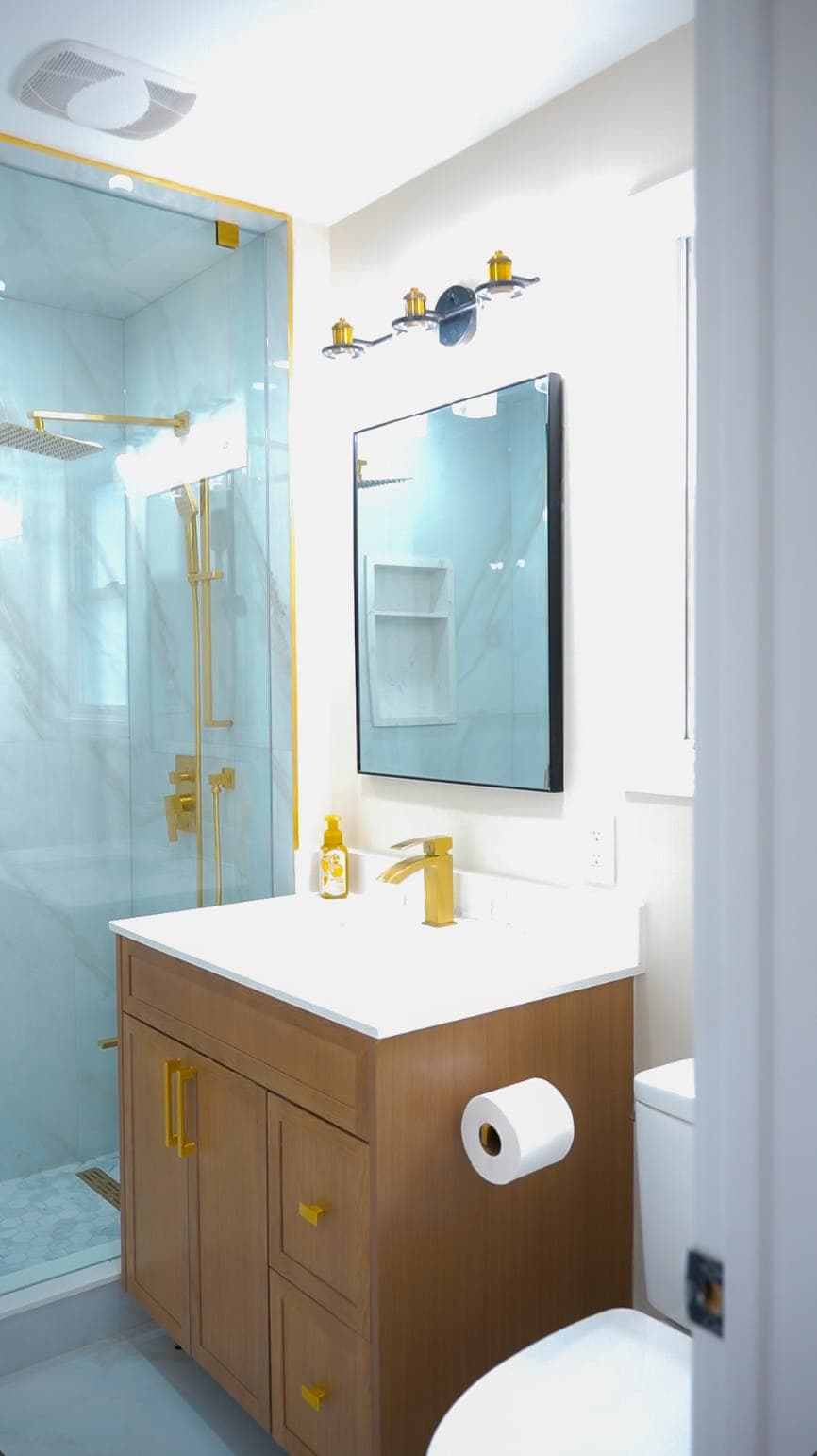 Bathroom vanity with mirror and gold fixtures