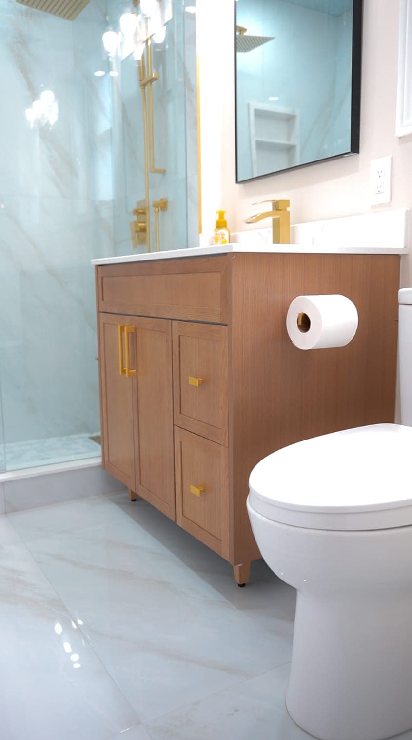 Bathroom vanity and toilet detail with wood cabinetry