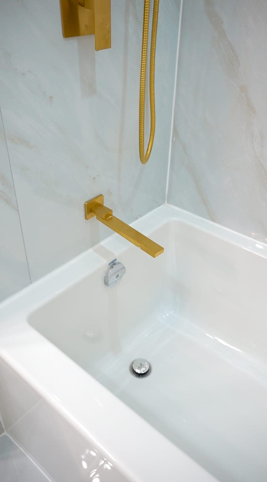 Freestanding tub with gold tub filler detail