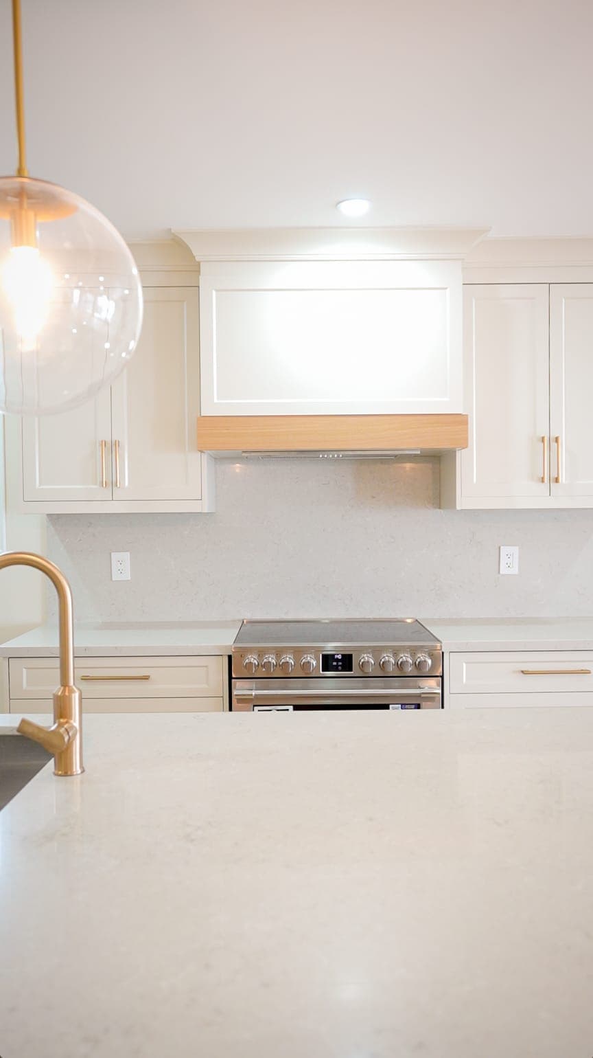 Kitchen range and custom wood range hood detail